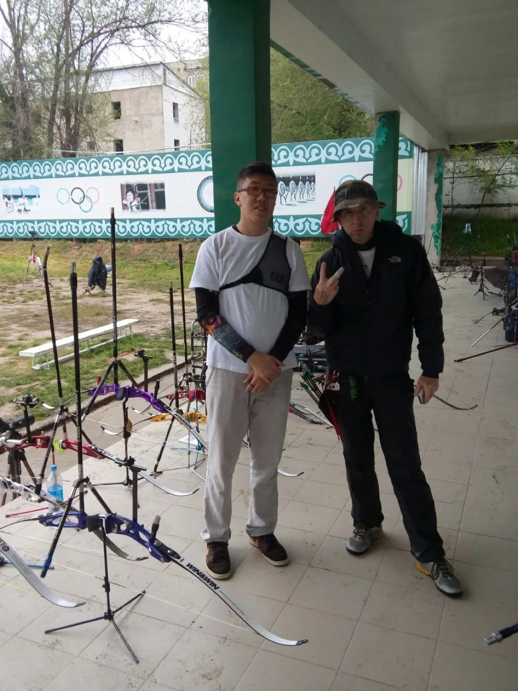 Holding a compound bow at an indoor range shortly after switching from recurve, 2016.