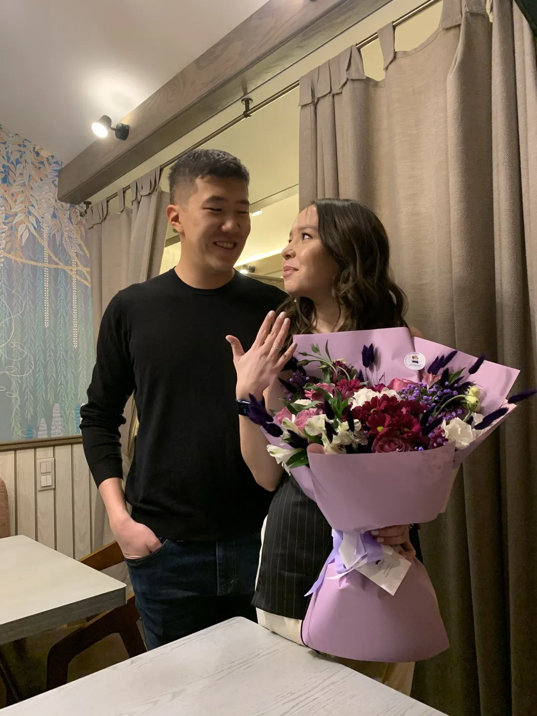 With my wife on the day we got engaged, holding a bouquet.